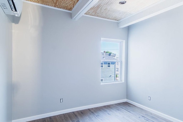 unfurnished room featuring hardwood / wood-style flooring, crown molding, and a wall mounted air conditioner