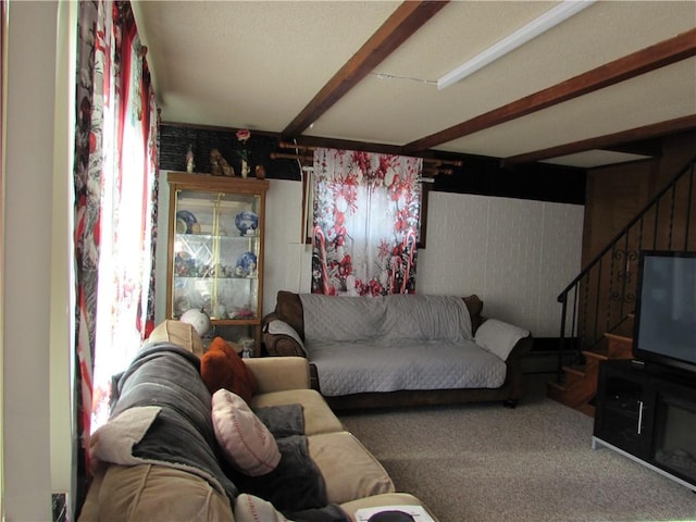 living room featuring beamed ceiling and carpet