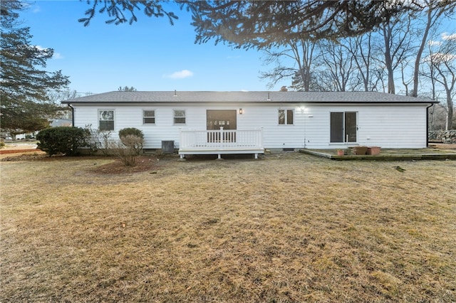 rear view of property with a wooden deck and a lawn