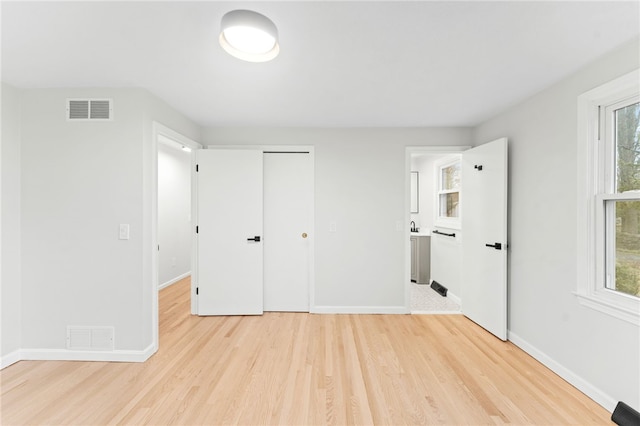 unfurnished bedroom featuring a closet and light hardwood / wood-style flooring