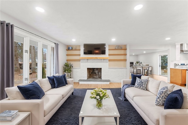 living room featuring hardwood / wood-style flooring and a brick fireplace