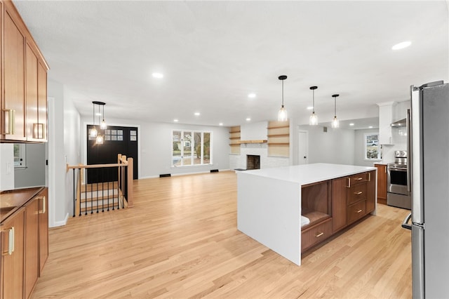 kitchen featuring stainless steel appliances, a kitchen island, light hardwood / wood-style floors, and decorative light fixtures