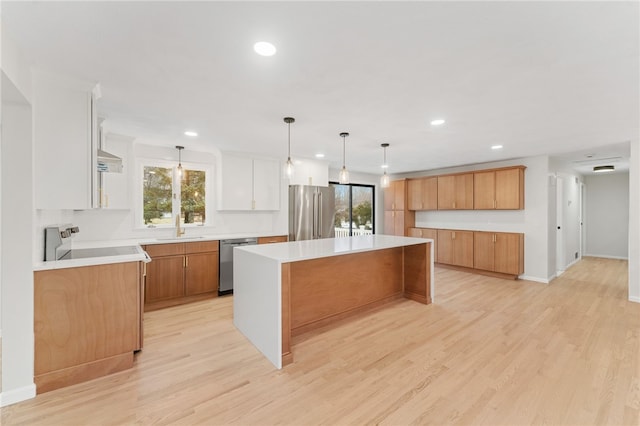 kitchen featuring sink, white cabinetry, a center island, pendant lighting, and stainless steel appliances