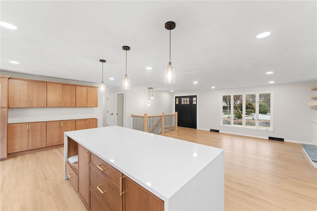 kitchen with pendant lighting, light hardwood / wood-style floors, and a kitchen island