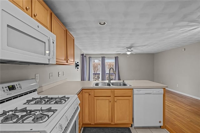 kitchen with sink, white appliances, ceiling fan, kitchen peninsula, and light wood-type flooring