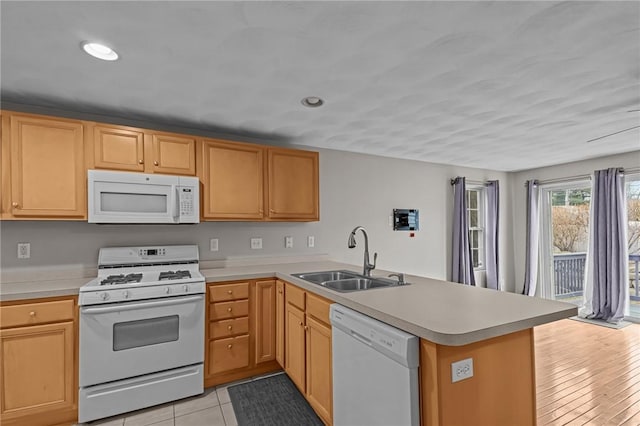 kitchen featuring white appliances, kitchen peninsula, sink, and light tile patterned floors