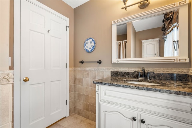 bathroom with vanity and tile walls