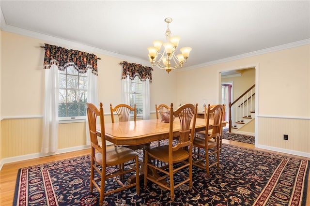 dining room featuring an inviting chandelier, hardwood / wood-style flooring, and ornamental molding