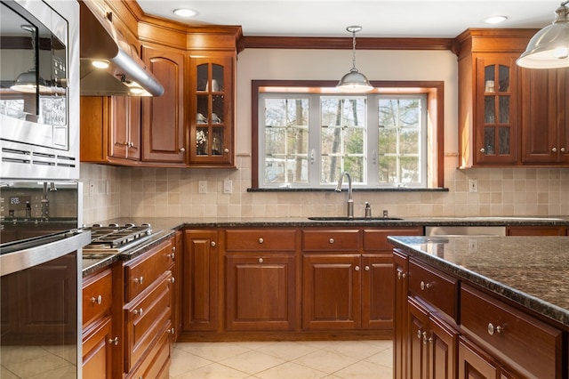 kitchen with sink, backsplash, ventilation hood, ornamental molding, and dark stone counters