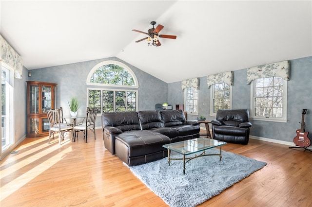 living room with ceiling fan, wood-type flooring, and high vaulted ceiling