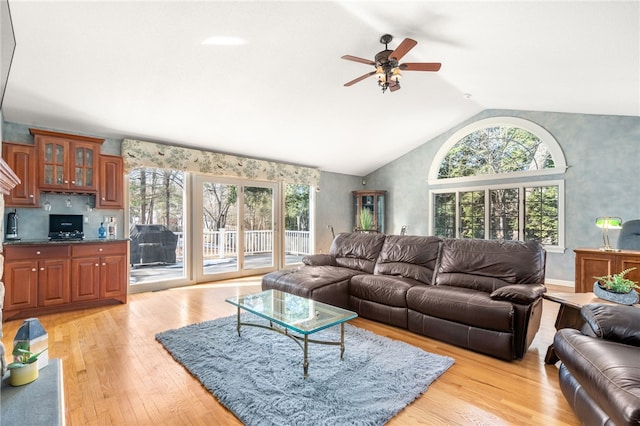 living room featuring vaulted ceiling, ceiling fan, and light hardwood / wood-style floors