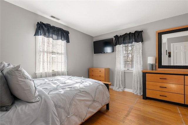 bedroom with multiple windows and light wood-type flooring