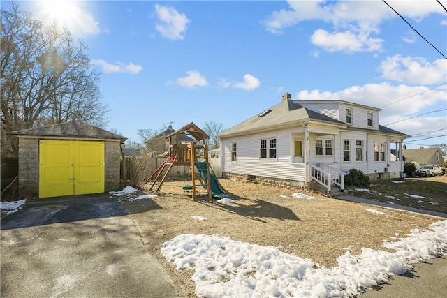 back of house featuring a playground and a storage shed