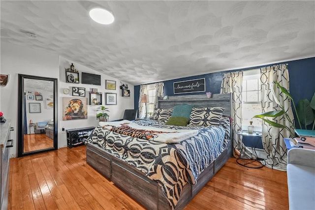 bedroom with hardwood / wood-style floors and vaulted ceiling