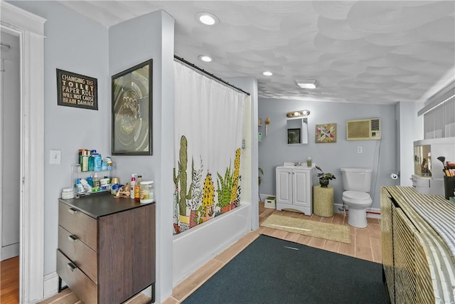 full bathroom featuring a wall mounted air conditioner, hardwood / wood-style floors, shower / bath combo with shower curtain, and toilet