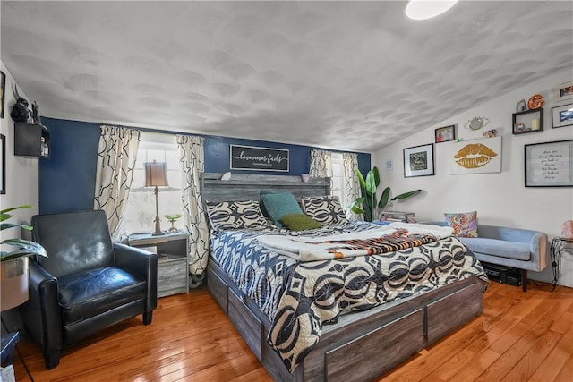 bedroom with wood-type flooring and lofted ceiling