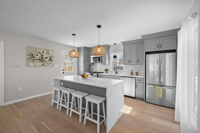 kitchen featuring sink, gray cabinets, a healthy amount of sunlight, and appliances with stainless steel finishes