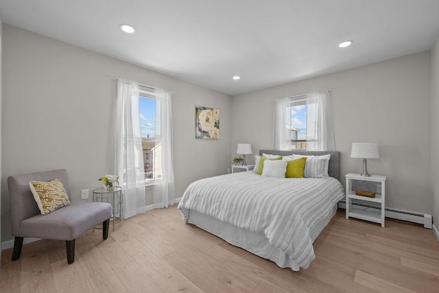 bedroom featuring light hardwood / wood-style floors and baseboard heating