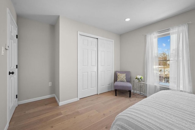 bedroom with a closet and light hardwood / wood-style flooring