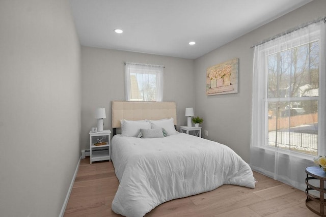 bedroom with light wood-type flooring and baseboard heating