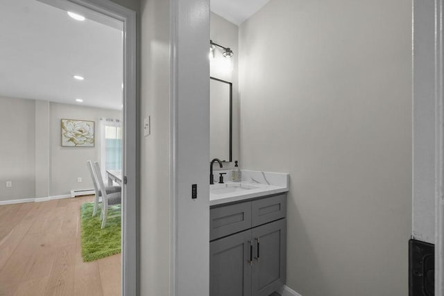 bathroom with a baseboard radiator, vanity, and hardwood / wood-style floors