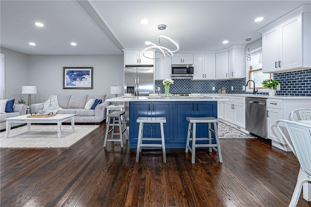 kitchen featuring white cabinetry, pendant lighting, stainless steel appliances, and a kitchen breakfast bar