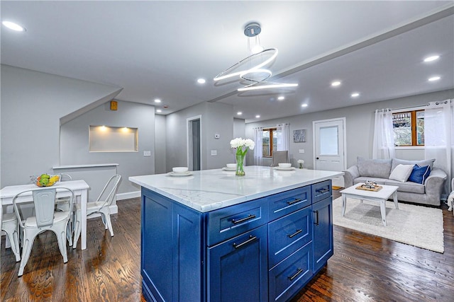 kitchen with blue cabinetry, dark wood-type flooring, plenty of natural light, a kitchen island, and pendant lighting