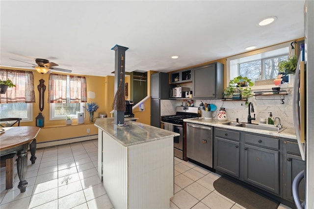 kitchen featuring sink, gray cabinets, appliances with stainless steel finishes, a kitchen island, and a baseboard radiator