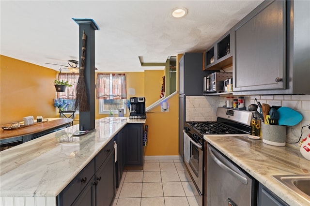 kitchen with light tile patterned floors, ceiling fan, stainless steel appliances, tasteful backsplash, and light stone counters