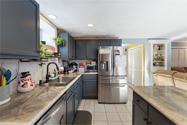 kitchen featuring light tile patterned flooring, sink, gray cabinetry, tasteful backsplash, and appliances with stainless steel finishes