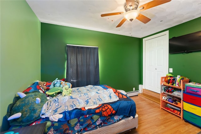 bedroom with wood-type flooring, ceiling fan, and baseboard heating