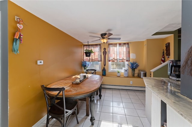 dining room with a baseboard heating unit, light tile patterned floors, and ceiling fan