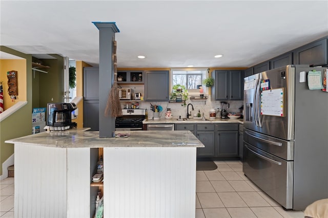 kitchen featuring sink, light tile patterned floors, stainless steel appliances, and backsplash