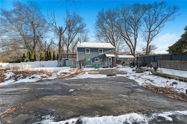 snow covered rear of property featuring a wooden deck