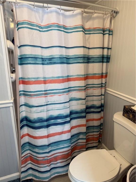 bathroom featuring a shower with curtain and toilet