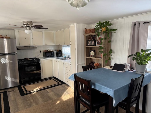 kitchen with dark wood-type flooring, ceiling fan, sink, and black appliances