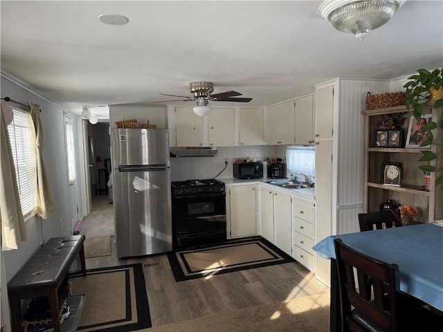 kitchen with sink, white cabinets, dark hardwood / wood-style floors, and black appliances