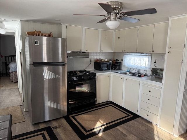 kitchen featuring dark wood-type flooring, white cabinets, sink, and black appliances