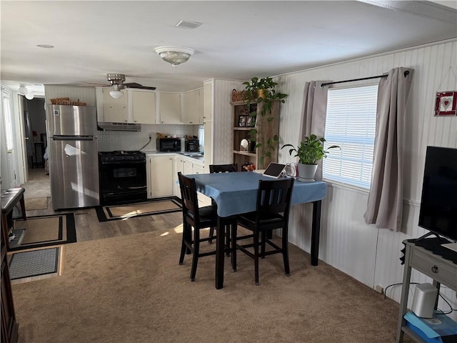 carpeted dining room with ceiling fan