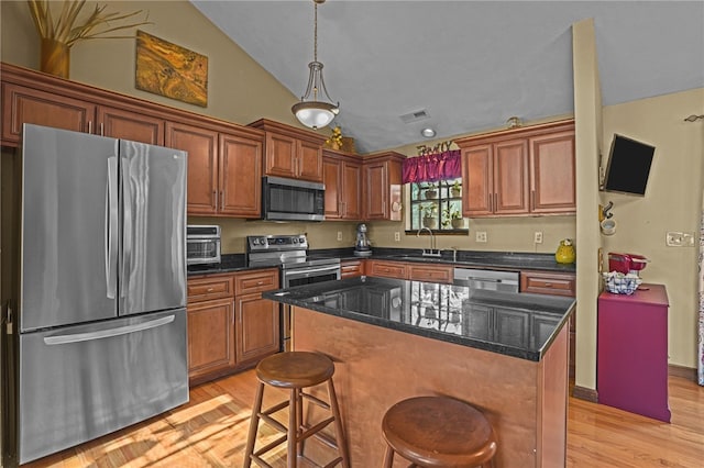 kitchen featuring sink, a center island, vaulted ceiling, light hardwood / wood-style flooring, and appliances with stainless steel finishes