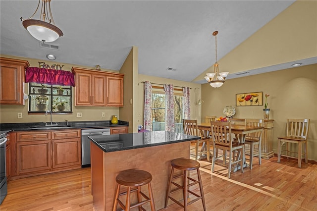 kitchen with sink, decorative light fixtures, stainless steel appliances, and a kitchen island