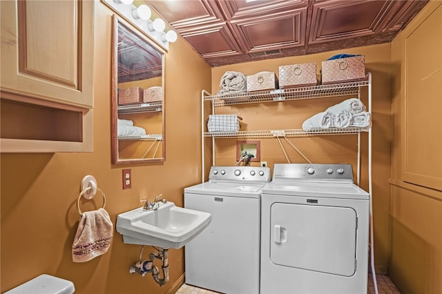 laundry room with cabinets, sink, and washer and clothes dryer