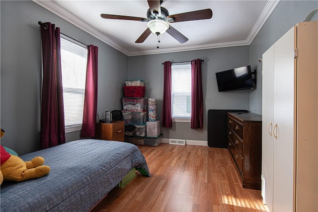 bedroom featuring ceiling fan, ornamental molding, and light hardwood / wood-style flooring