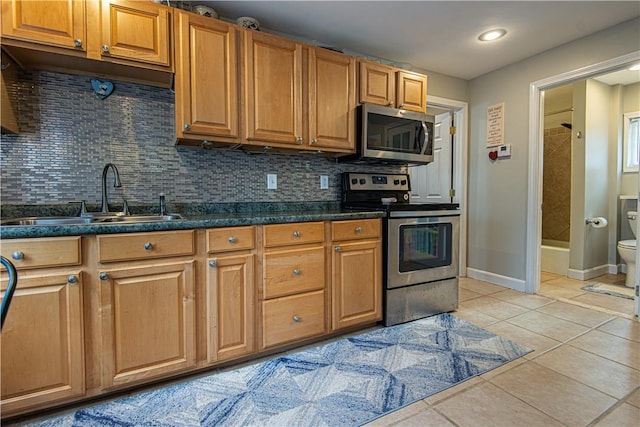 kitchen with stainless steel appliances, sink, light tile patterned floors, and decorative backsplash