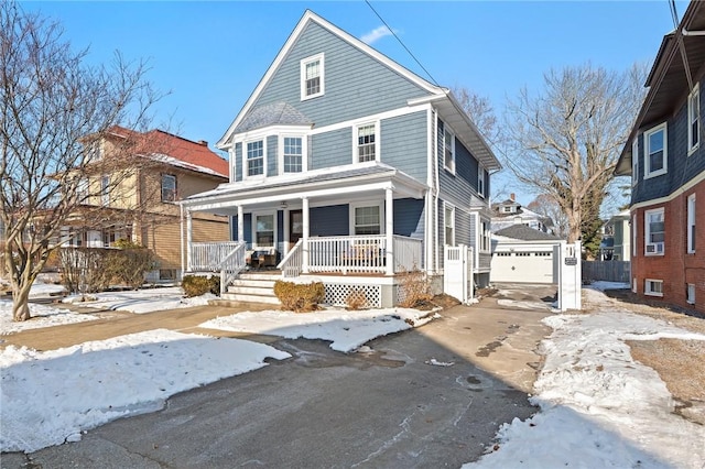 view of front property featuring a garage, an outdoor structure, and covered porch