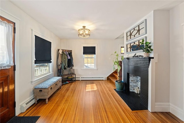 living room featuring hardwood / wood-style floors, a baseboard radiator, and a fireplace