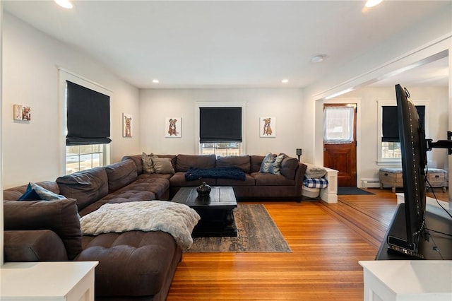 living room featuring wood-type flooring and baseboard heating