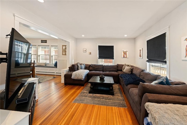 living room with a baseboard radiator and light hardwood / wood-style flooring