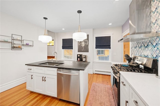 kitchen featuring range hood, sink, white cabinetry, and stainless steel appliances