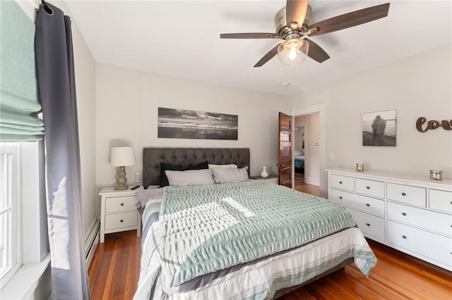 bedroom featuring a baseboard heating unit, dark wood-type flooring, and ceiling fan